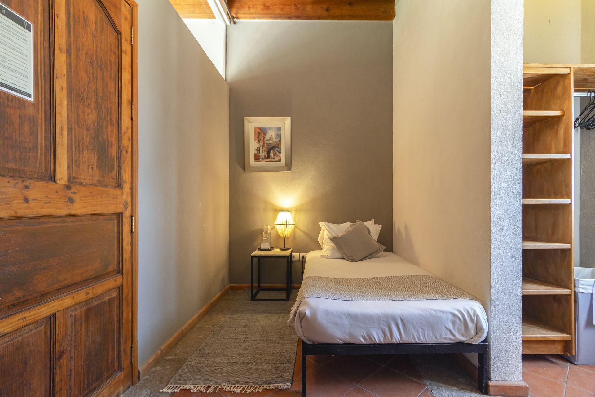 A small bedroom with a single bed and a closet.