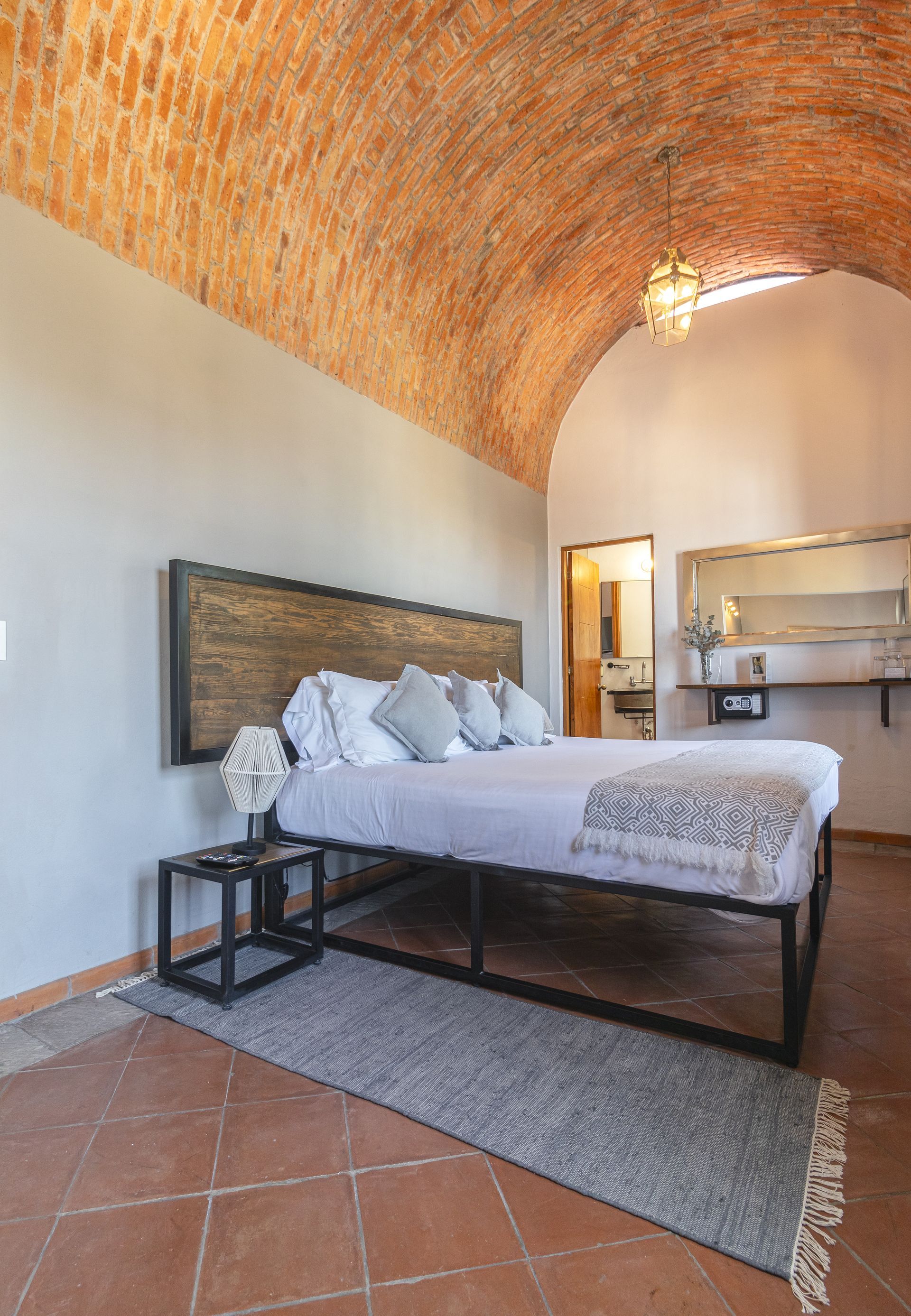 A bedroom with a bed and a brick ceiling