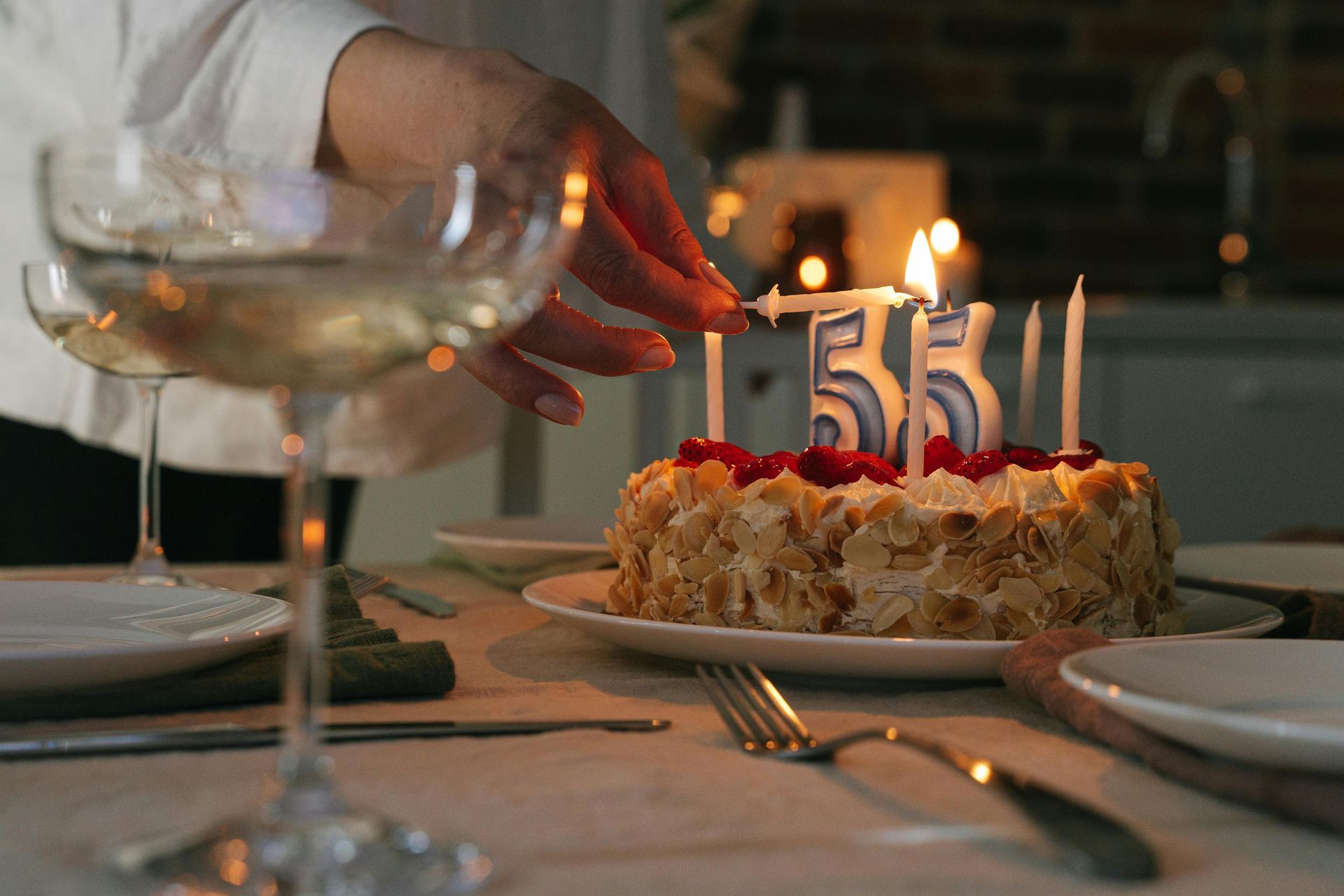 Person lighting candles on a cake with 