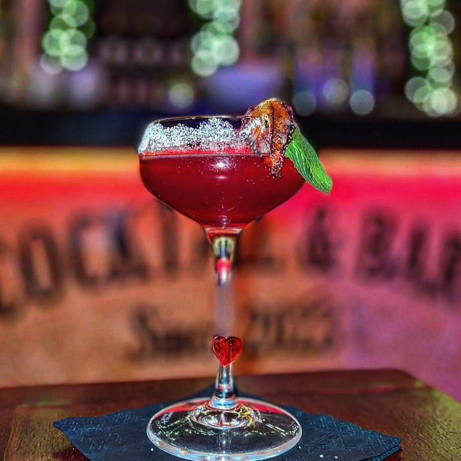 un primo piano di un cocktail in un bicchiere di vino su un tavolo.