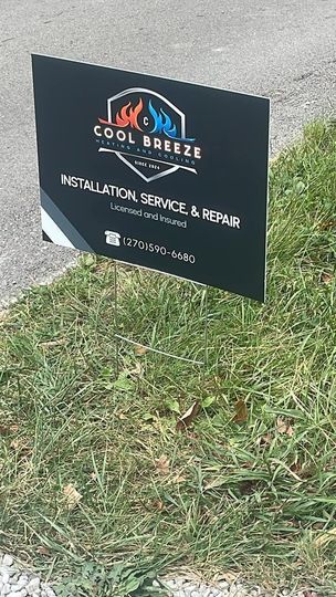 Cool Breeze sign on grass; black background, logo with flames, offers installation, service, and repair.