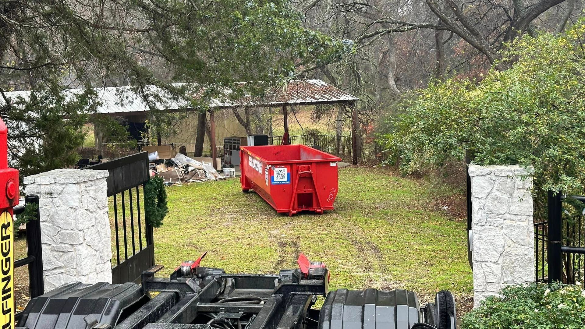 a large red 20 yard dumpster parked on a front lawn