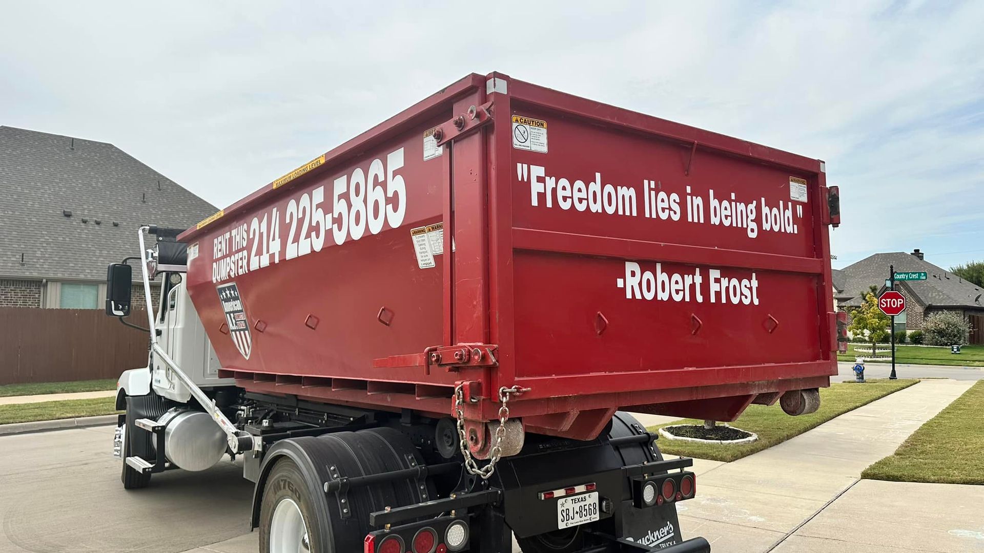 a red dumpster truck is parked on the side of the road with a quote written on the back by robert