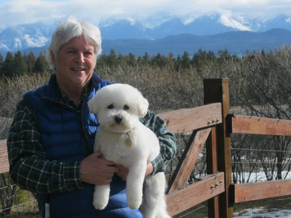 Man Carrying Bichon Frise Dog — Lakeside, MT — Monica's Pet Grooming & Boarding