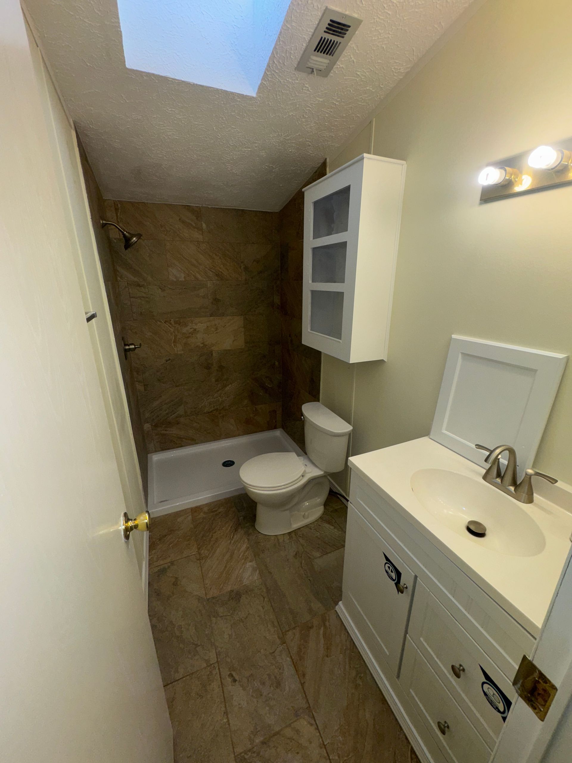 a man is kneeling down to install a tile floor in a room .