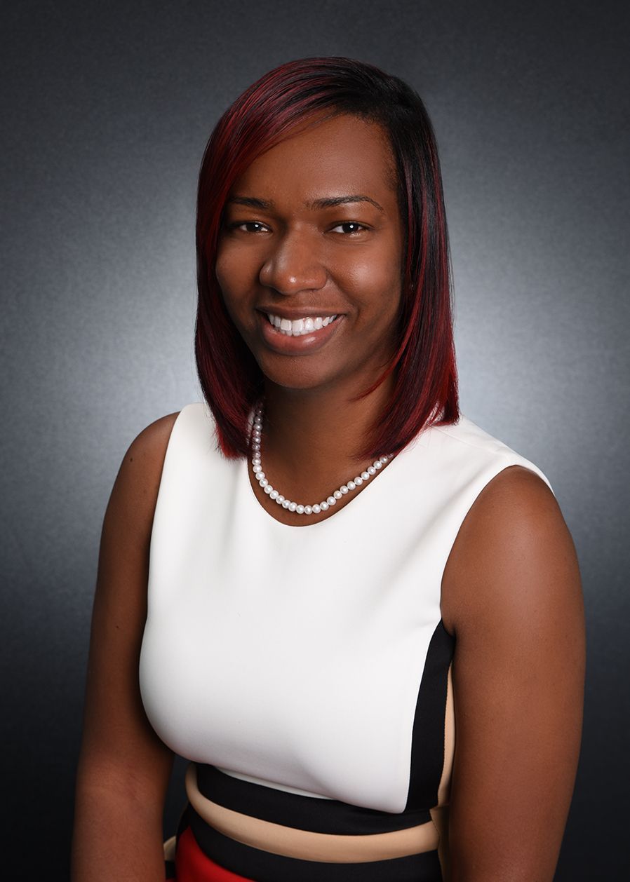 A woman is holding a clipboard and a home for sale sign