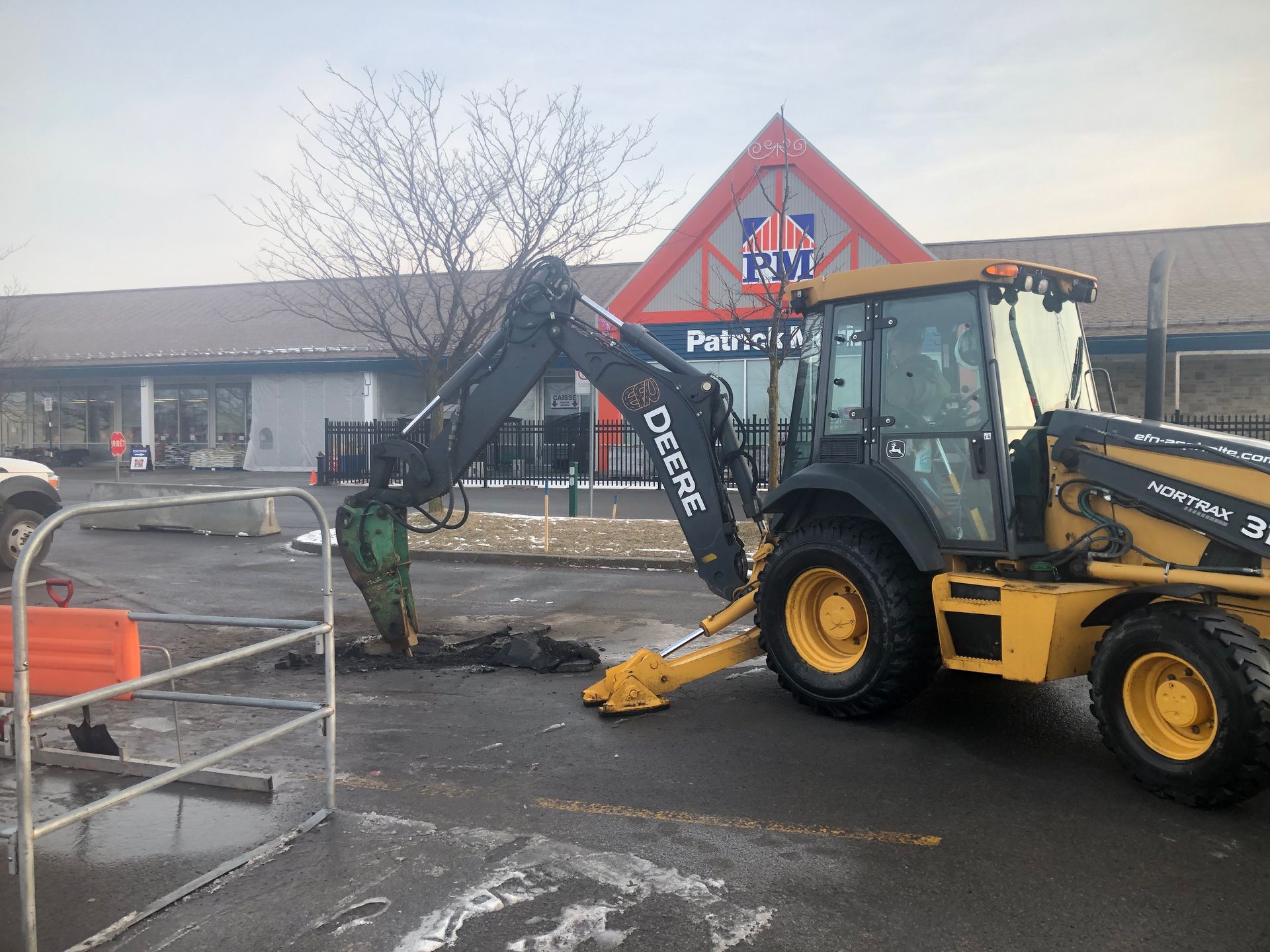 Un tracteur Deere est garé devant un bâtiment
