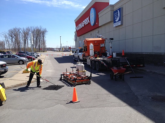 Un homme travaille sur la route devant un magasin appelé aquafix