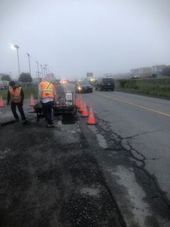 Un groupe d'ouvriers du bâtiment travaillent sur le bord d'une route.