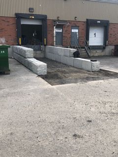 Un bâtiment en brique avec un quai de chargement et des escaliers devant.