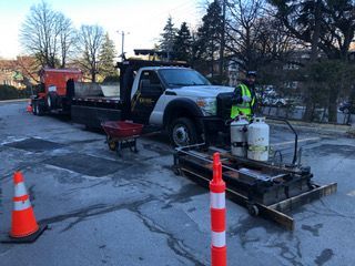 Un homme se tient à côté d'un camion dans un parking.