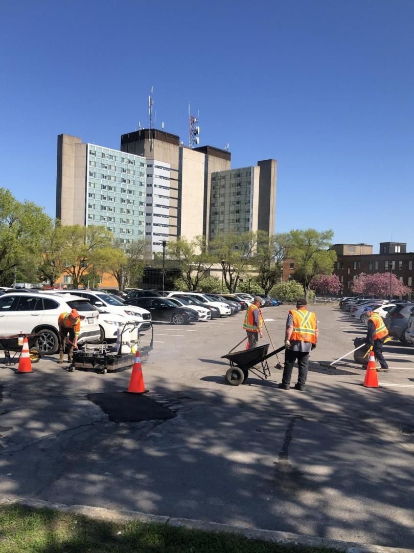 Un groupe d'ouvriers du bâtiment travaillent dans un parking.