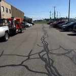 De nombreuses voitures sont garées sur un parking devant un immeuble.
