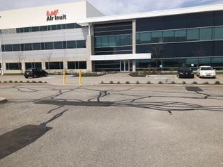 Un grand bâtiment avec beaucoup de fenêtres et des voitures garées devant.