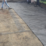 Une personne se tient debout sur un morceau de toile de jute au sol.