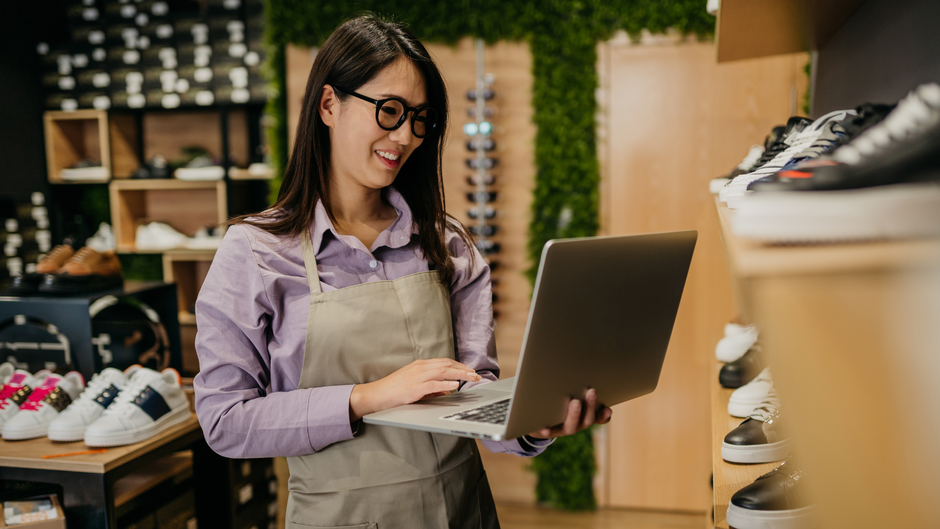 A woman is using a laptop computer in a shoe store.