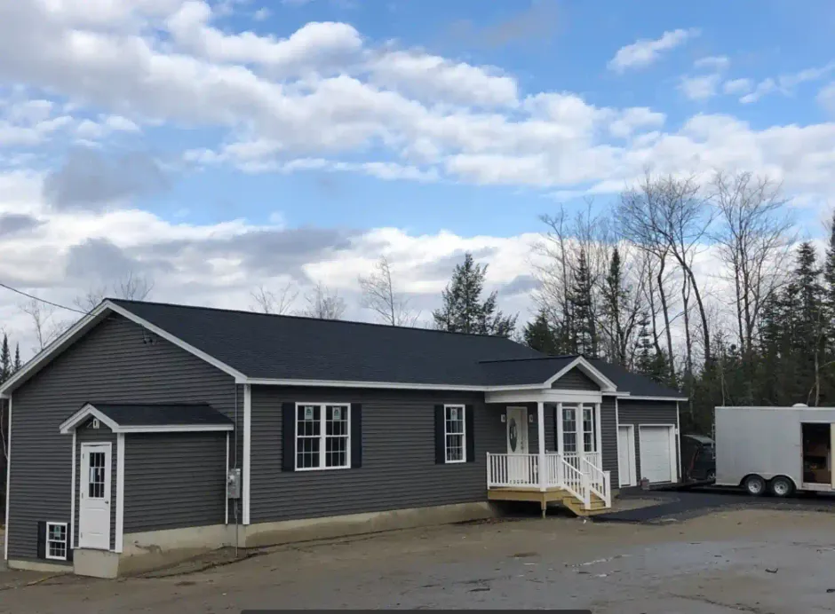 A large house with a trailer parked in front of it.