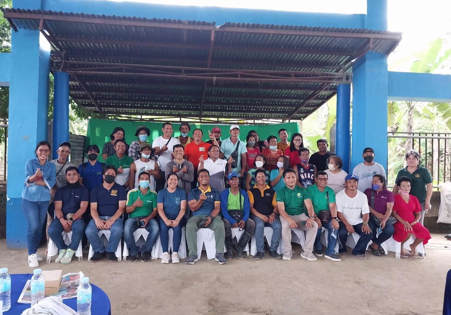 A group of people are posing for a picture in front of a blue building.