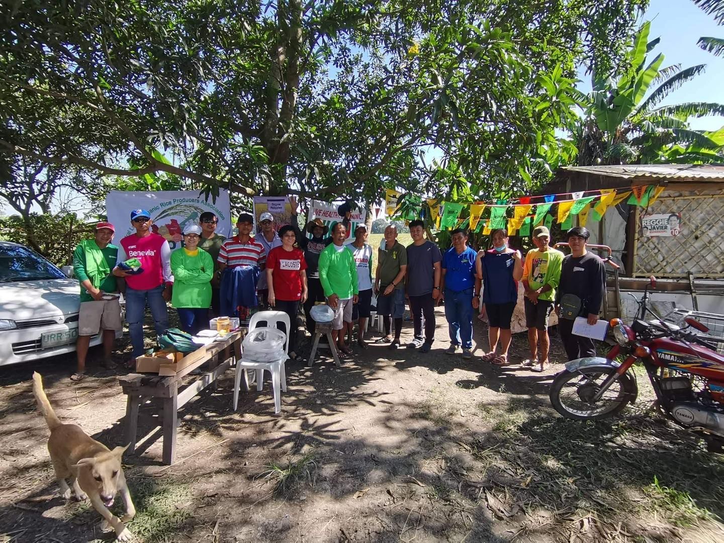 A group of people are posing for a picture in front of a motorcycle.
