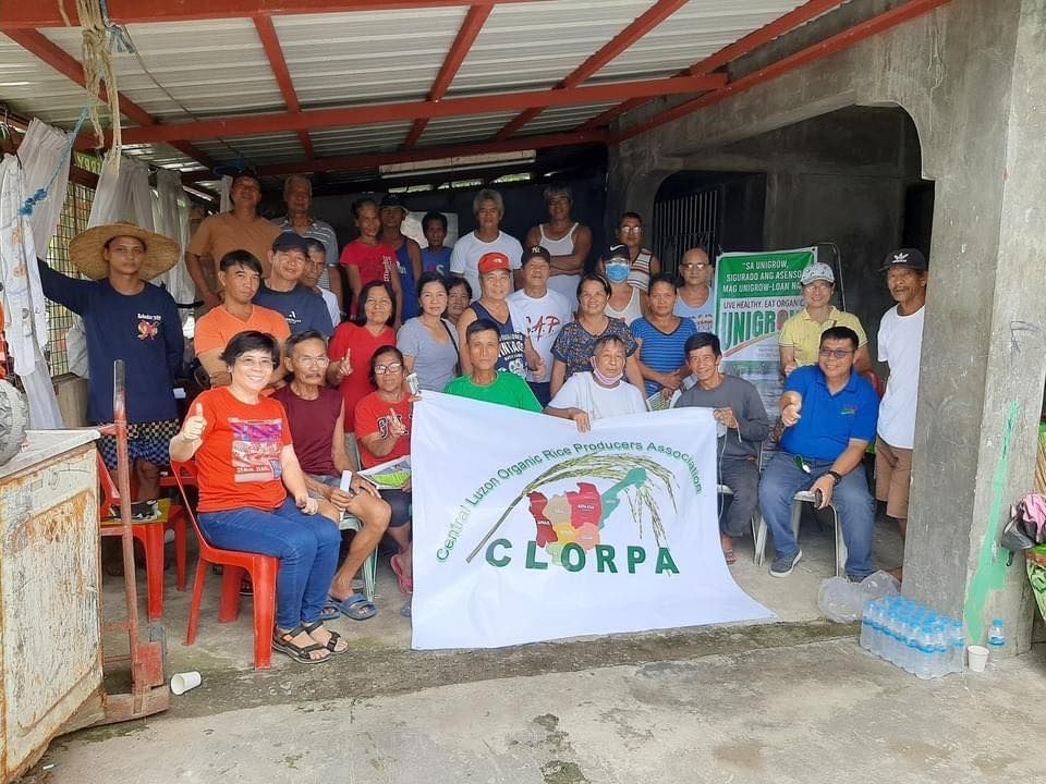 A group of people are posing for a picture in front of a sign that says clorpa.