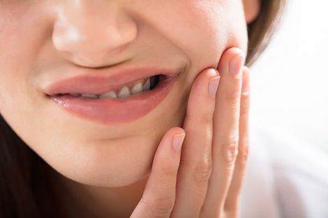 Dental Crown — Woman Holding Her Jaw in Mansfield, OH