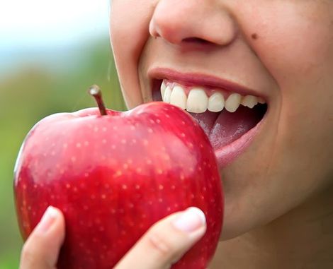 Cosmetic Dentist — Woman Eating Apple in Mansfield, OH