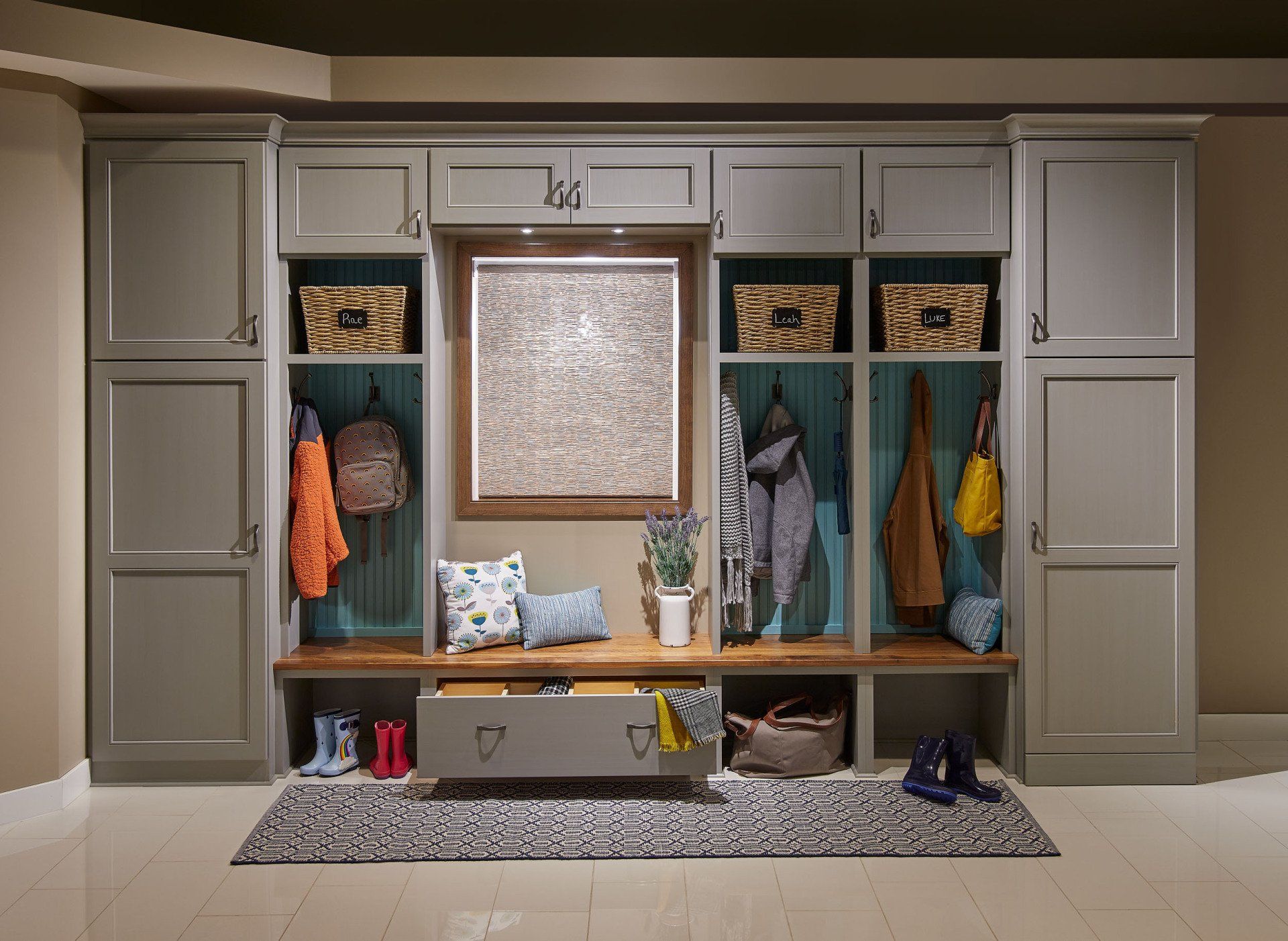 A mud room with lots of cabinets and a bench.