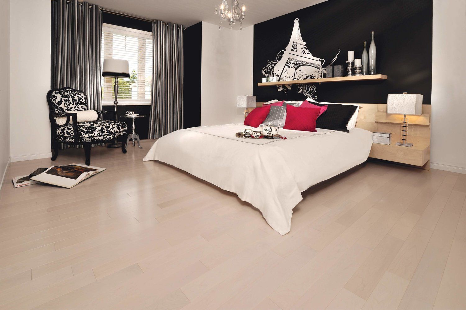 A bedroom with a large bed and a chair