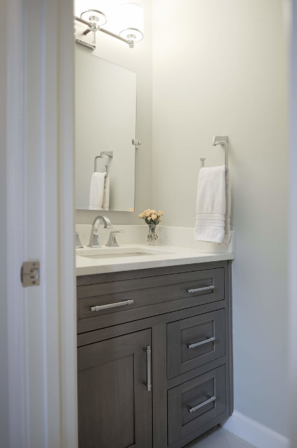 A bathroom with a sink , mirror and towel rack.