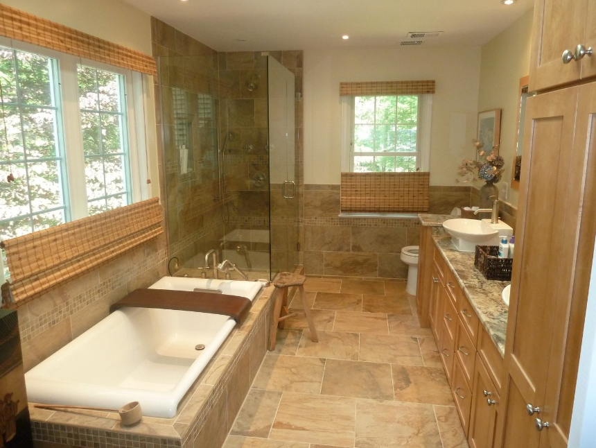 A bathroom with a tub , sink , toilet and window.