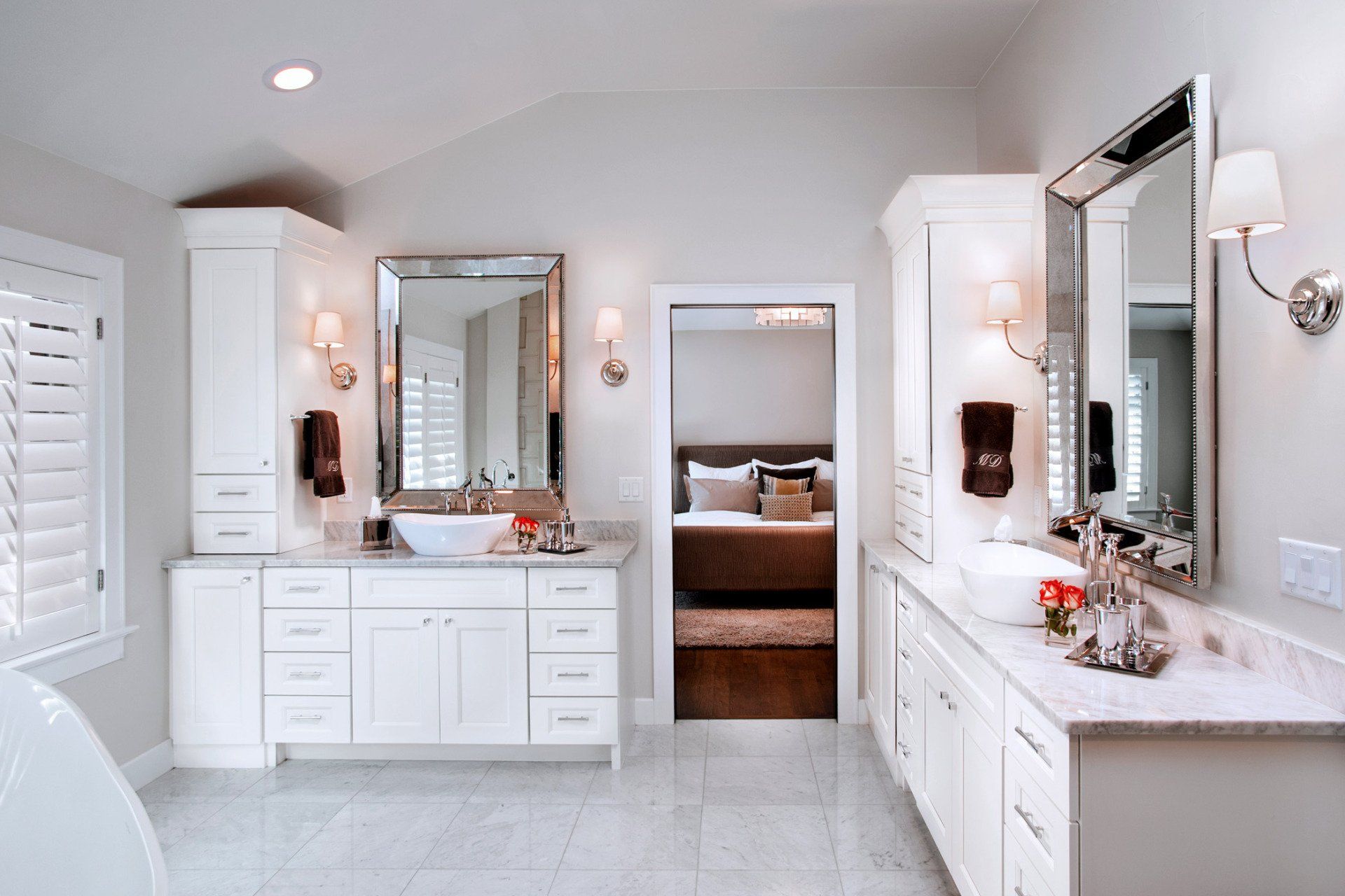 A bathroom with two sinks , two mirrors and a bathtub.