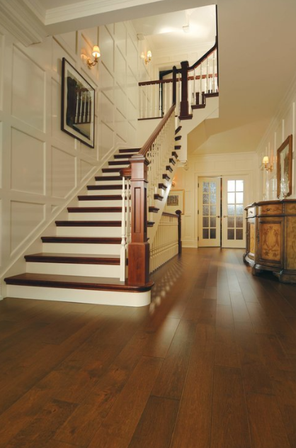 A hallway with a staircase and a wooden floor