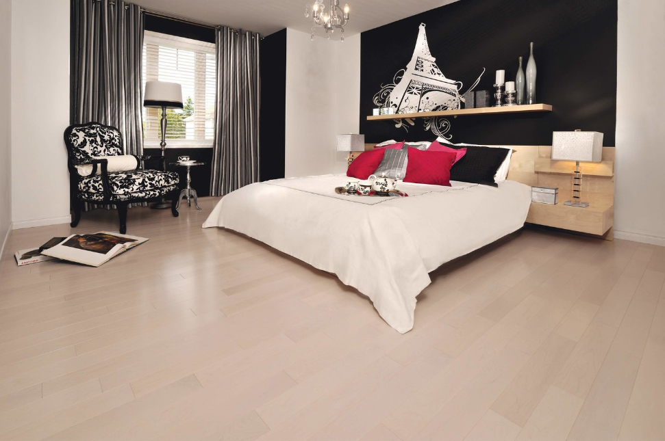 A bedroom with a large bed and a chair