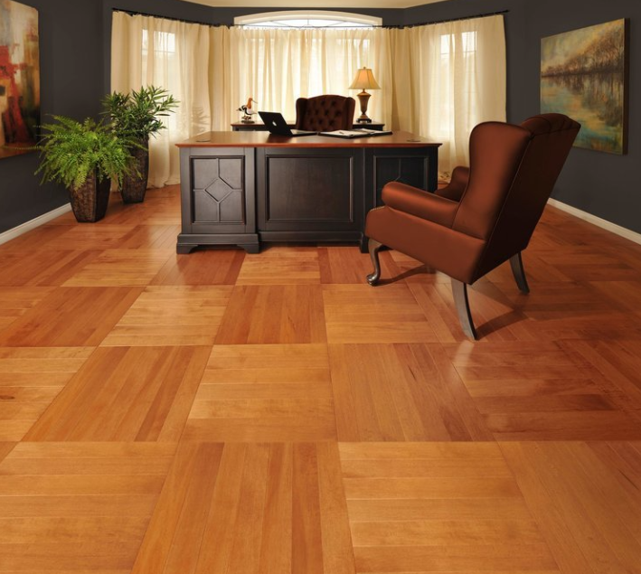 A living room with hardwood floors and a desk and chair