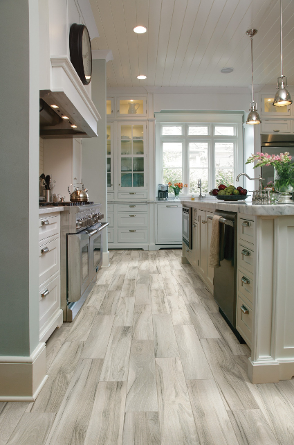 A kitchen with a wooden floor and white cabinets.