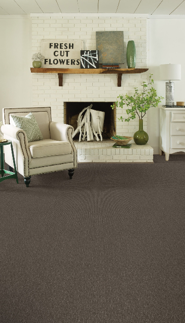 A living room with a fireplace , chair , and carpet.