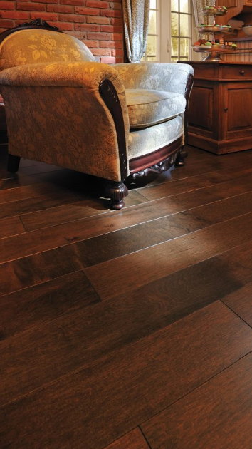 A chair and a table are sitting on a wooden floor in a living room.