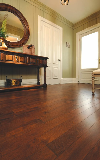 A hallway with hardwood floors and a mirror on the wall