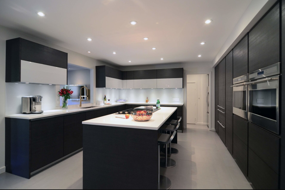 A kitchen with black cabinets and stainless steel appliances