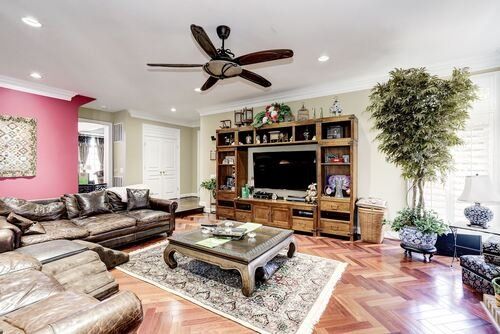 A living room filled with furniture and a ceiling fan.