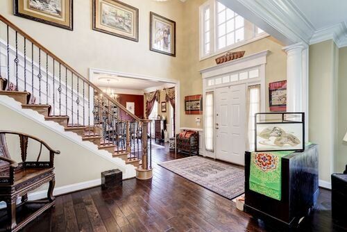 A living room with hardwood floors and stairs leading up to the second floor.