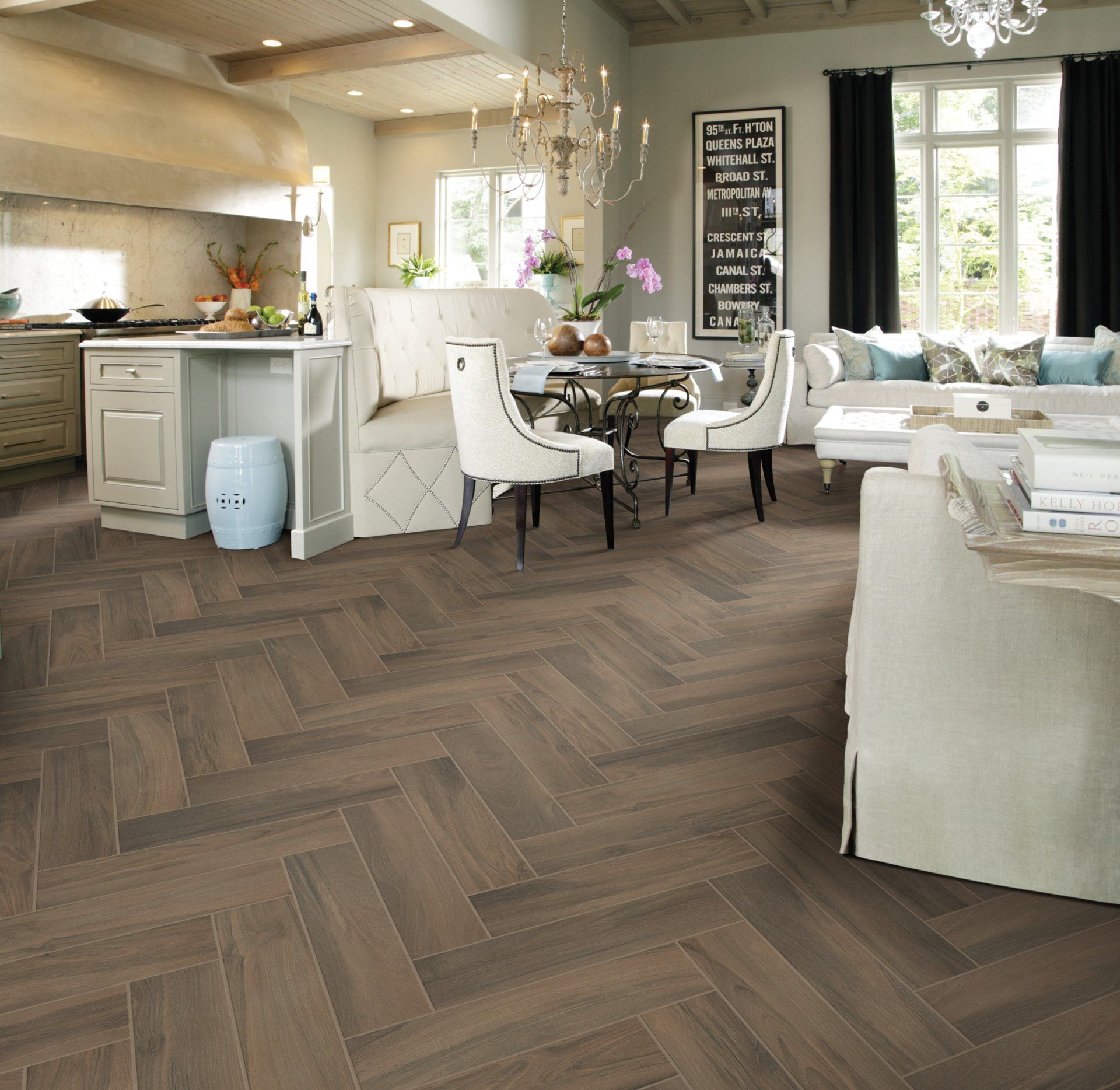 A living room with a herringbone floor and white furniture