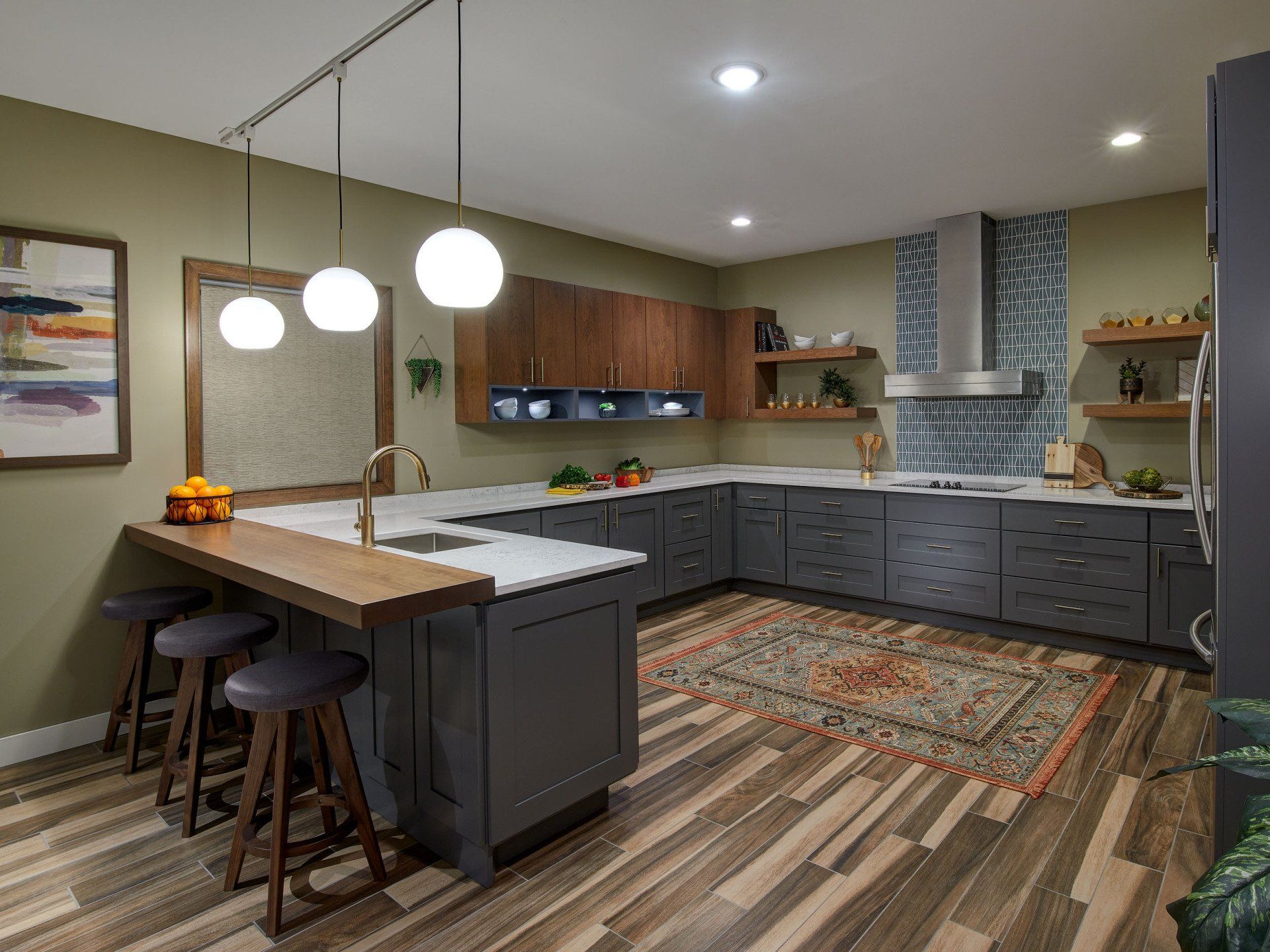 A kitchen with a large island , stools , and a sink.