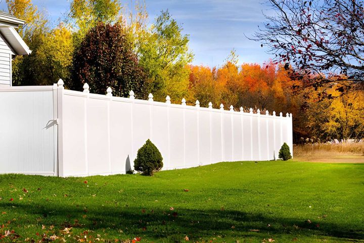 Long white vinyl privacy fence in backyard