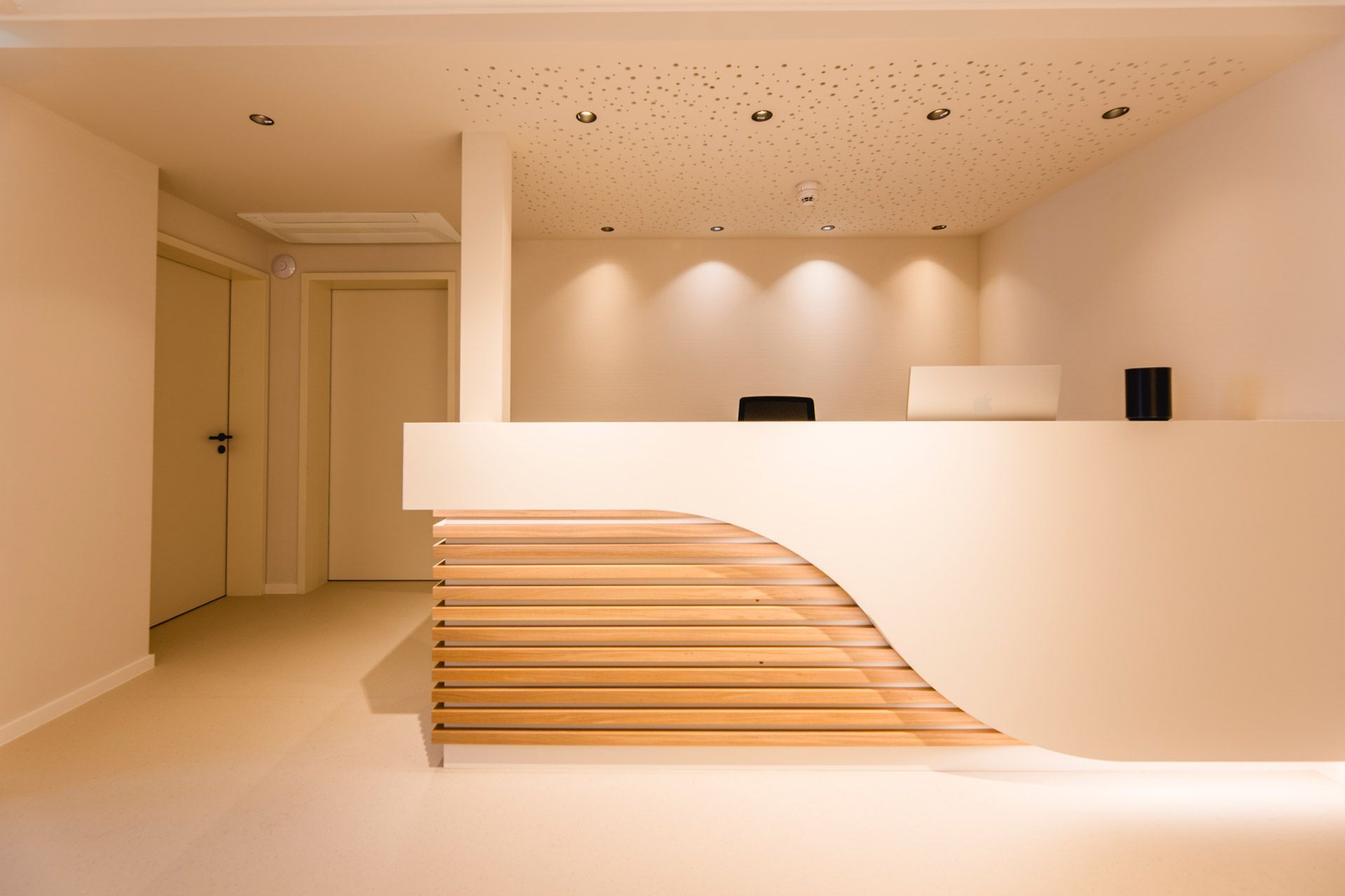 Empfang einer Arztpraxis mit einer Designertheke, teils aus Holz
