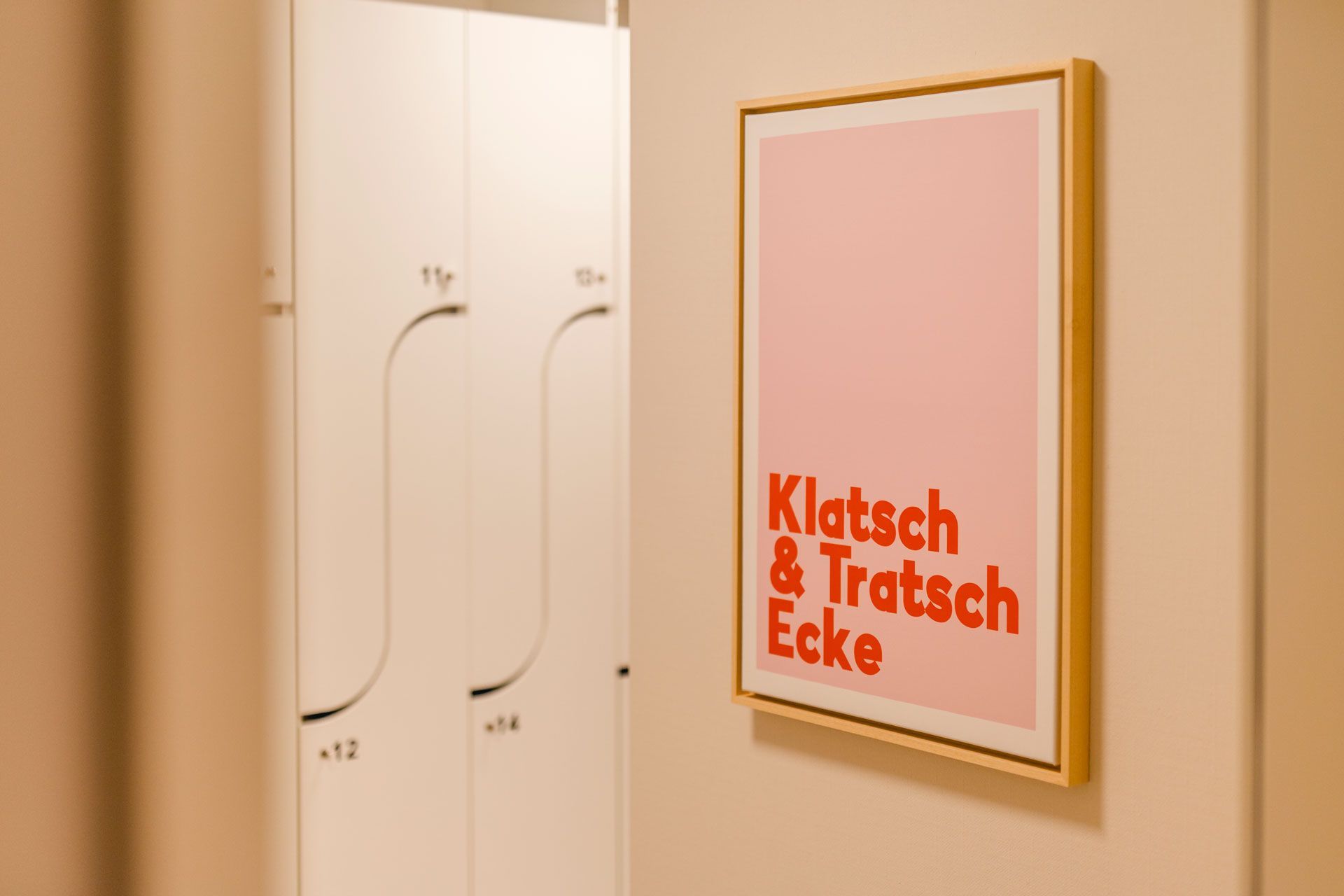 Mitarbeiterspinte mit Nummern und Schlüsseln, Sonderanfertigung, Türen mit Schwung, Bild an der Wand mit Schrift: Klatsch und Tratschecke