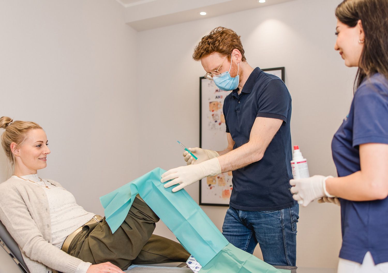 Spritze und blaue Flüssigkeit in einem Fläschen in einer Hand