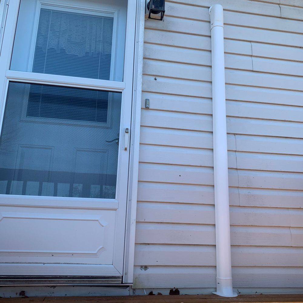 A white house with a door and a white pipe