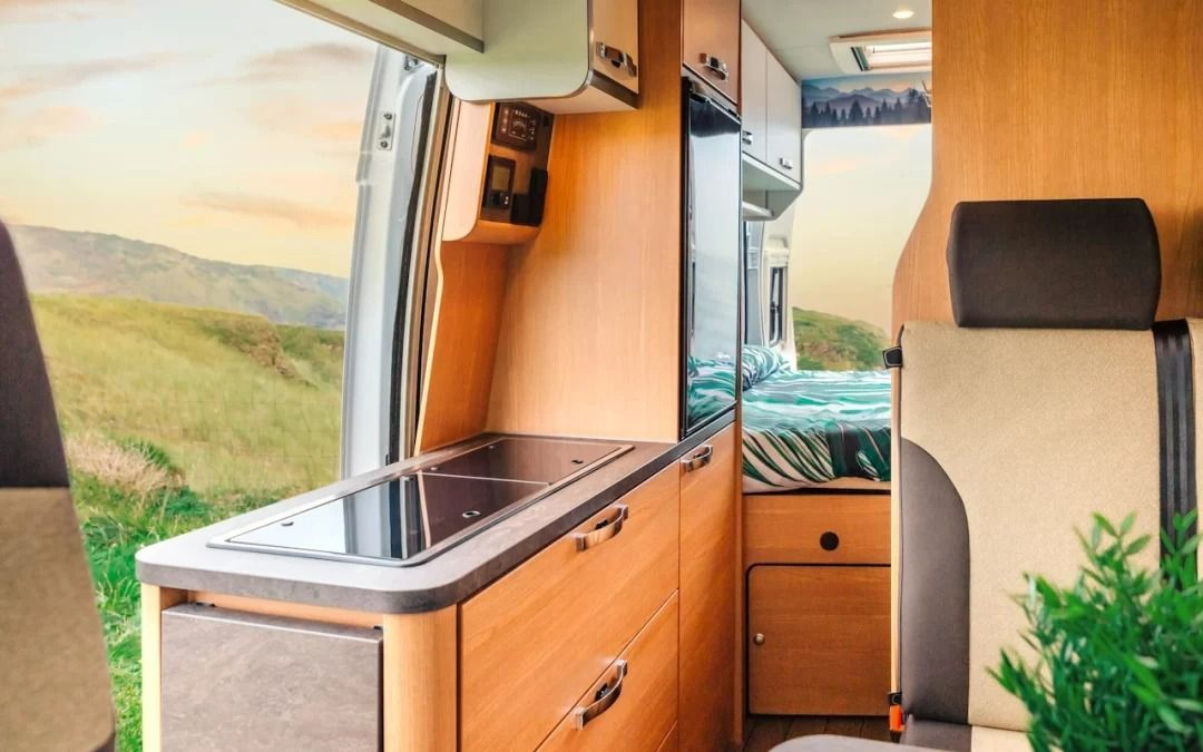 The inside of a camper van with a kitchen and a toilet.