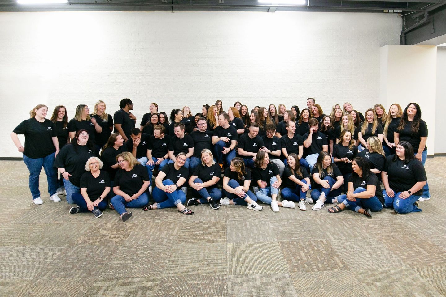 A large group of people are posing for a picture in a room.